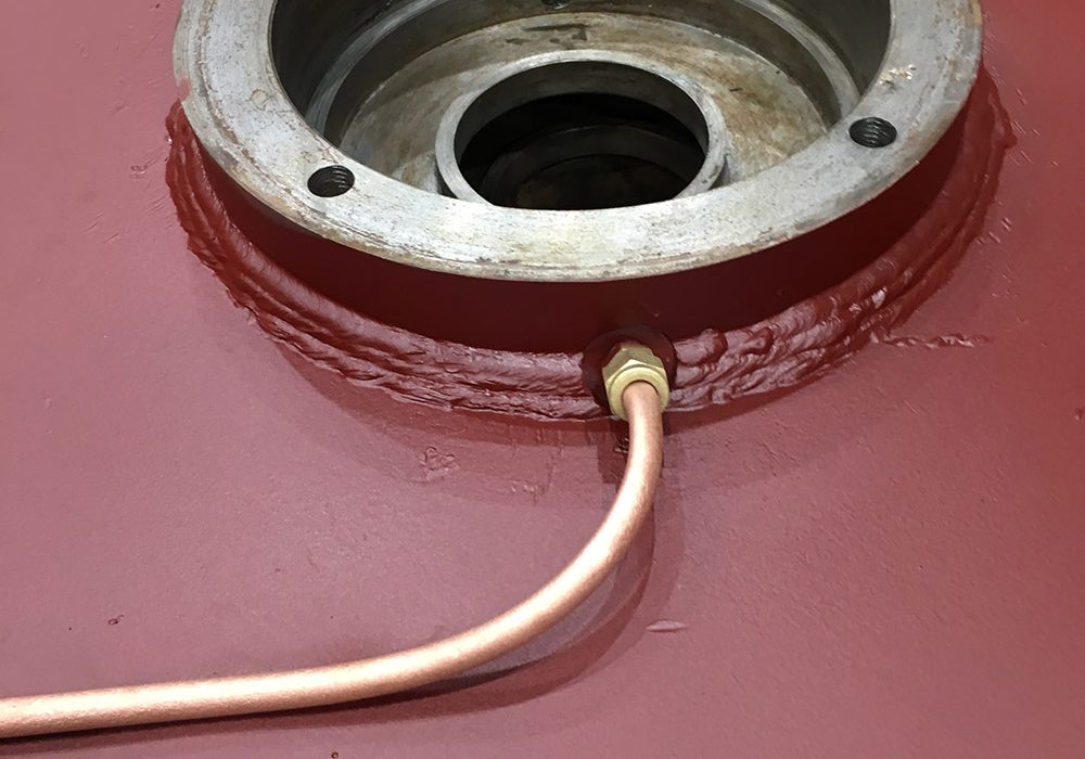 Grease tubes and ports for greasing the bearings in a compressor motor