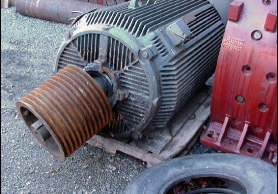 failed industrial electric motor sitting on asphalt